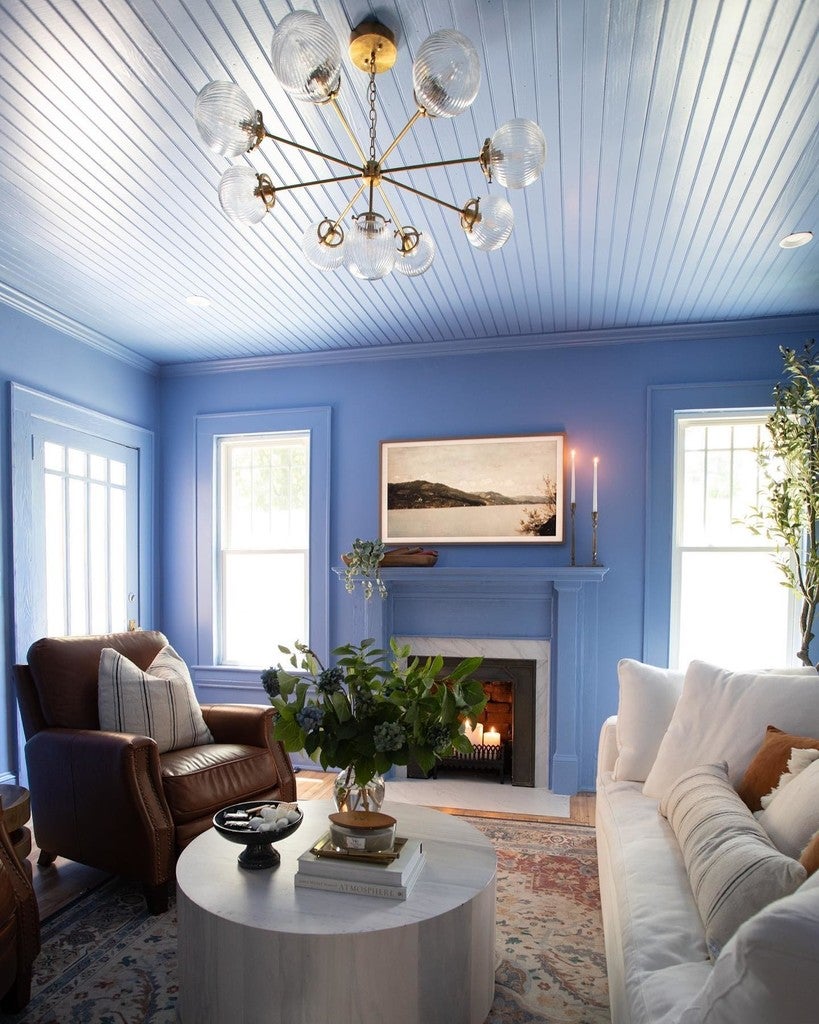Living room with blue walls, white ceiling, and a fireplace.