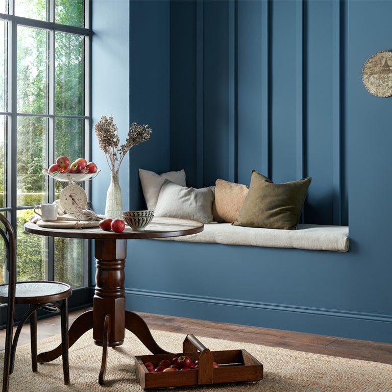 Room with a wooden table, decorative items, and a blue wall.