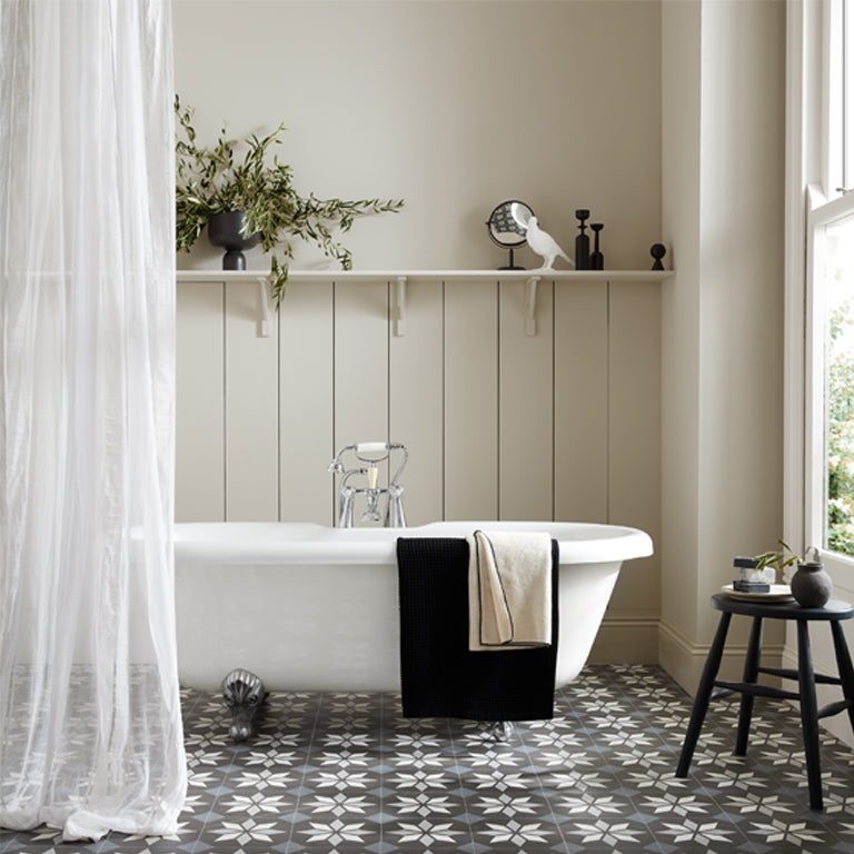 Bathroom with a freestanding bathtub, decorative shelf, and patterned floor.