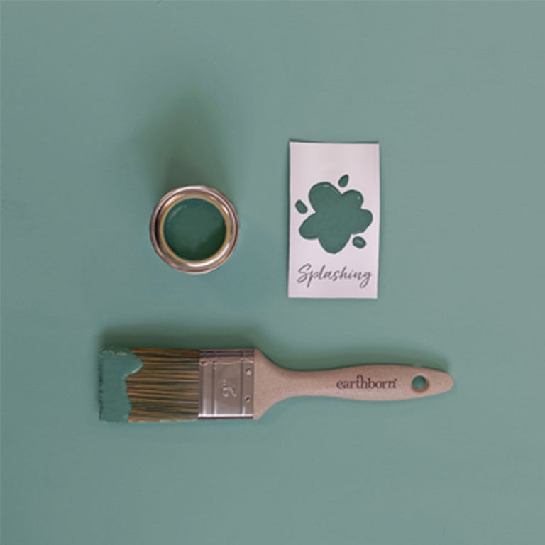 Paintbrush, paint can, and stencil with 'earthborn' brand on a green background