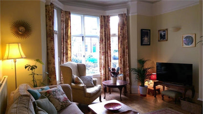 Living room with yellow walls, large window, and decorative elements.