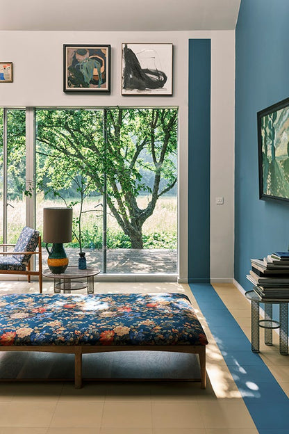 Modern living room with floral bench, large window, and decorative wall art.