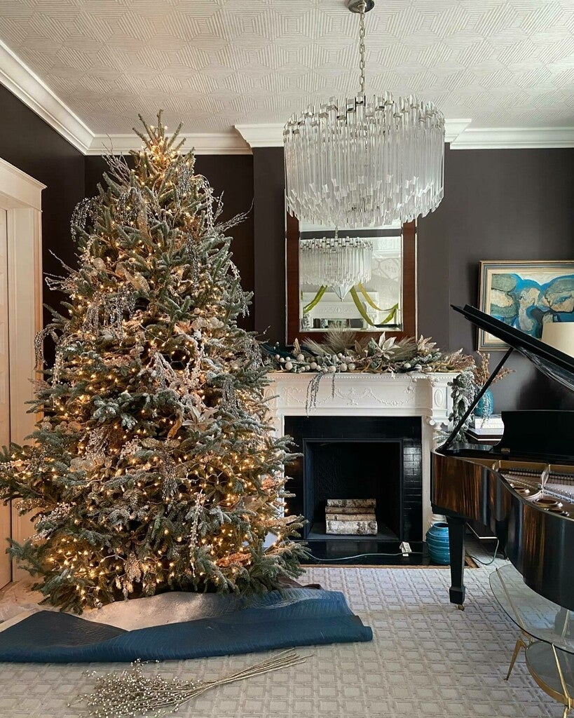 Decorated Christmas tree in a living room with a fireplace and piano.