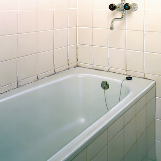 White bathtub in a bathroom with tiled walls
