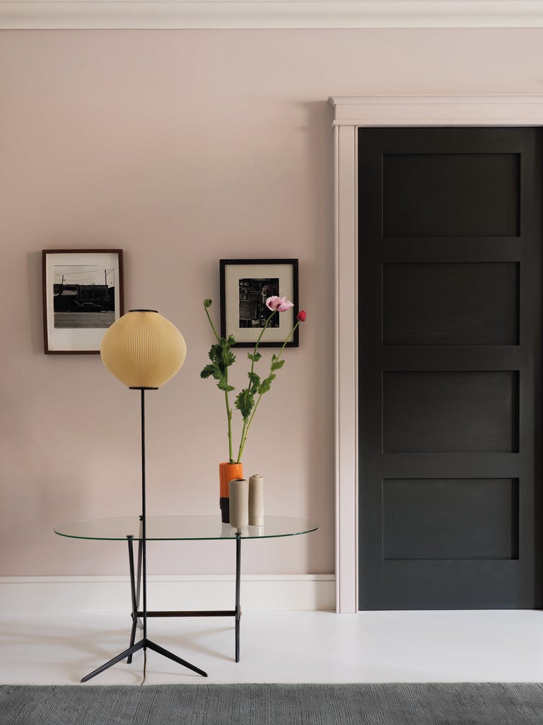 Modern interior with a black door, glass table, and decorative items.