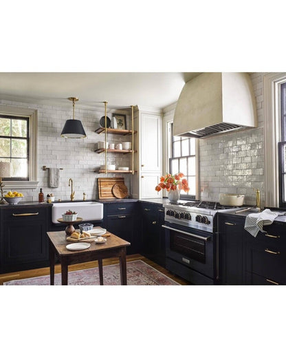 Modern kitchen with black appliances, white countertops, and decorative elements.