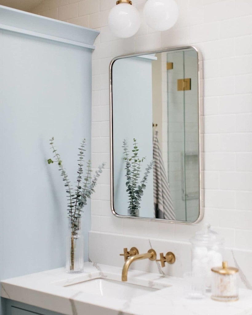 Bathroom with a mirror, sink, and decorative elements.