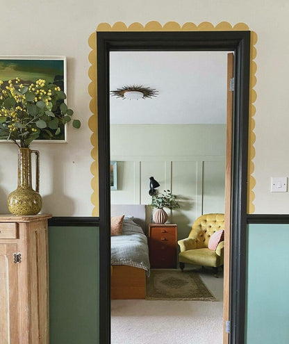 Room with a mirror reflecting a bedroom, wooden cabinet, and decorative elements.