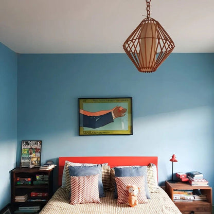 Bedroom with blue walls, a red headboard, and decorative pillows.