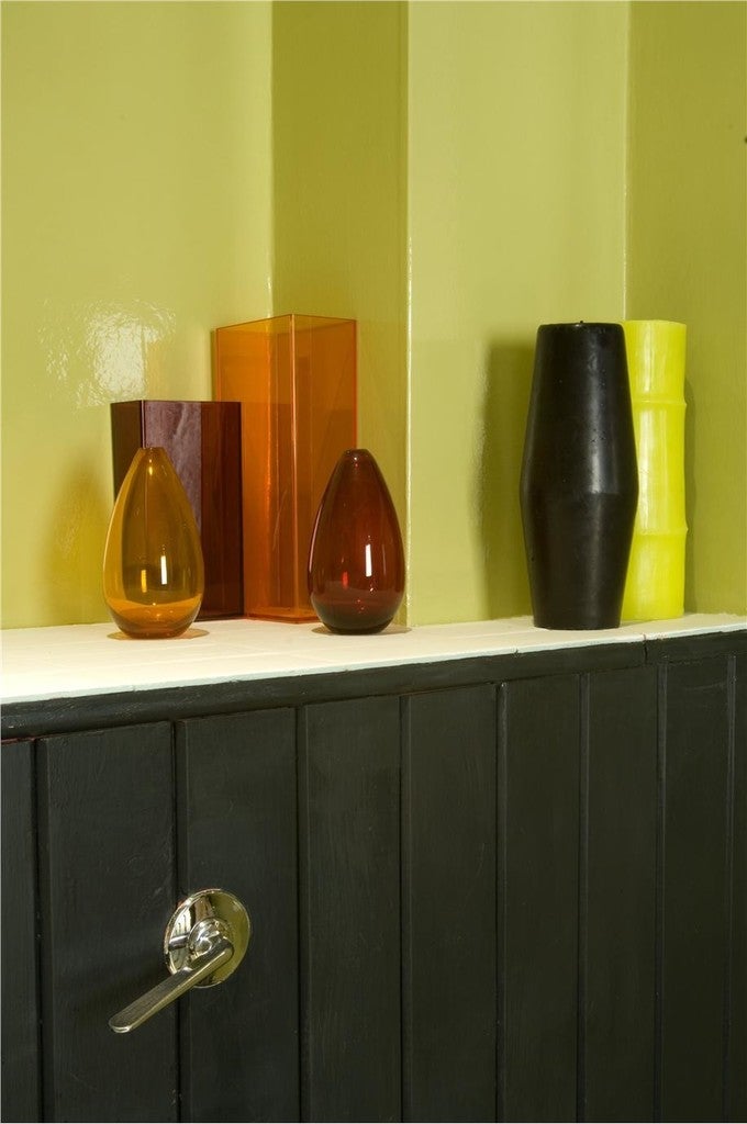 Vases on a shelf against a green striped wall