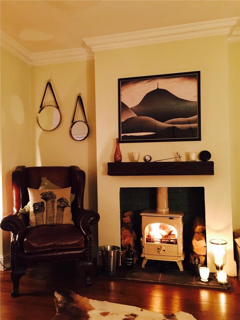Cozy living room with a fireplace, armchair, and decorative items.