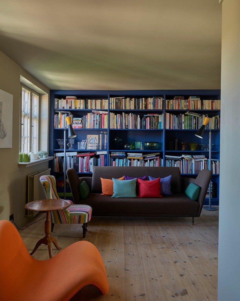 Living room with a bookshelf, sofa, and colorful chair.