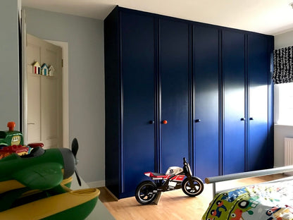 Blue wardrobe in a child's room with toys on the floor