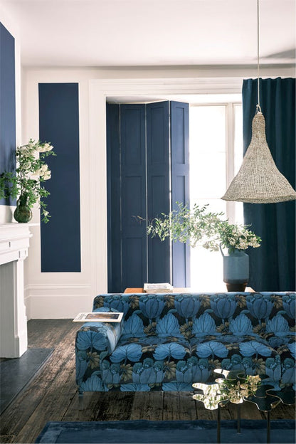 Living room with blue sofa, white walls, and decorative elements.
