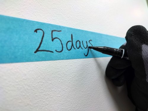 Handwriting '25 days' on a blue strip with a black pen, on a white background.