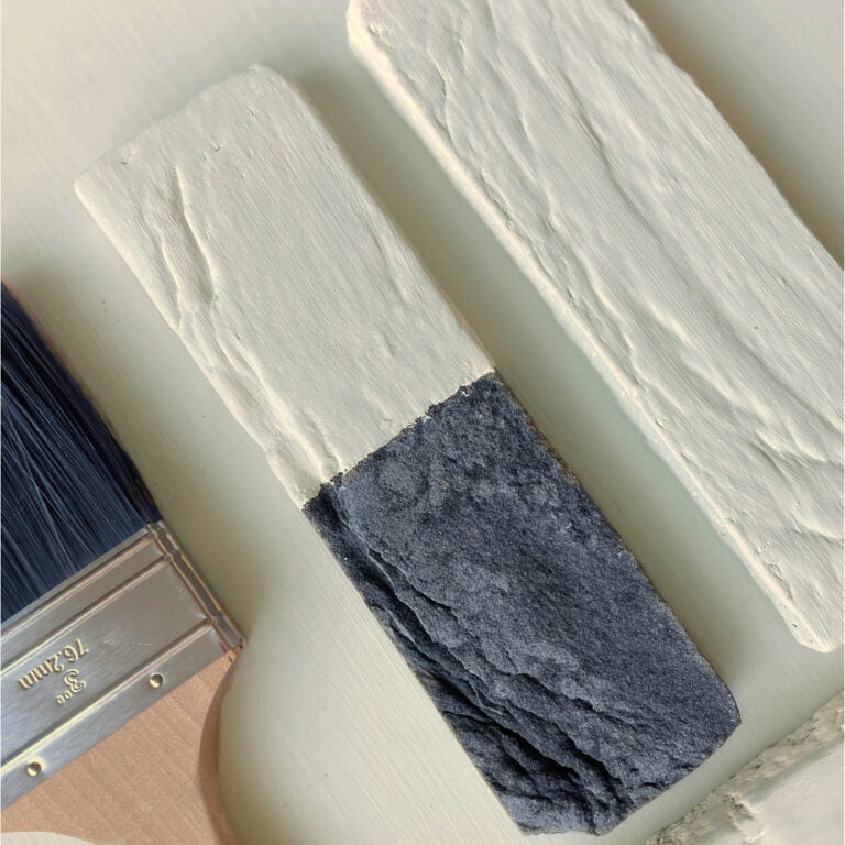 Paintbrush with white paint on a light-colored surface