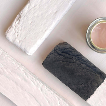 Bar of soap and a small container on a white surface