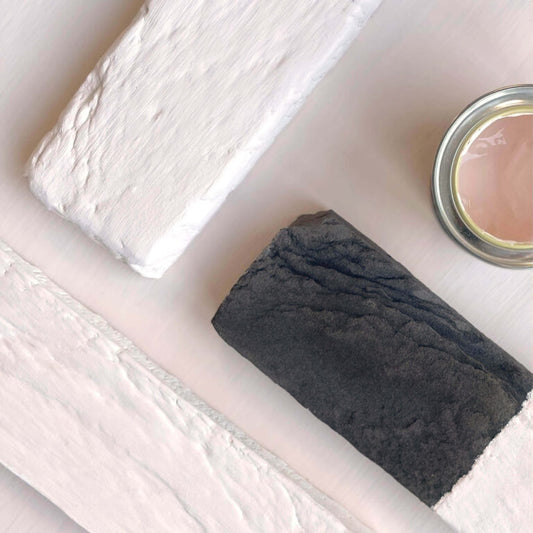 Bar of soap and a small container on a white surface