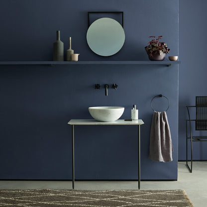 Bathroom with dark blue walls, white sink, and decorative elements.