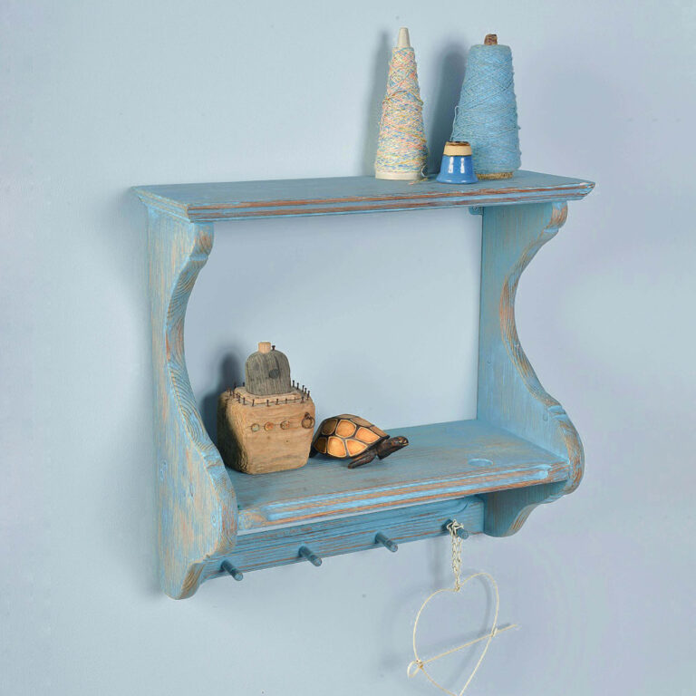 Blue wooden shelf with decorative items against a light blue background