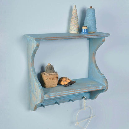 Blue wooden shelf with decorative items against a light blue background