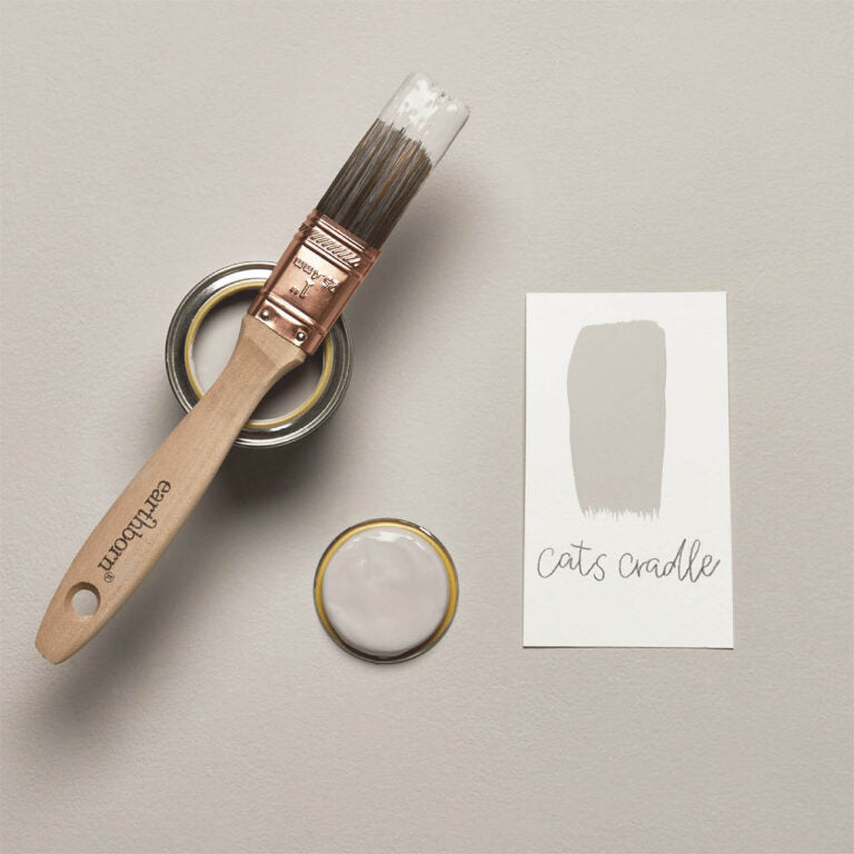 Paintbrush, paint can, and color swatch labeled 'cats cradle' on a neutral background