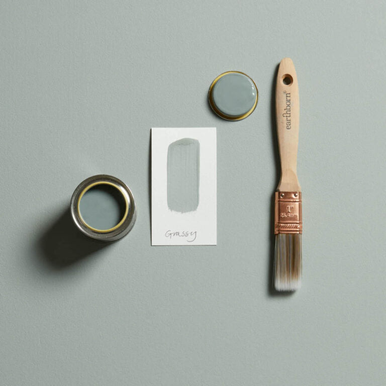 Paint can, brush, and paper on a gray background