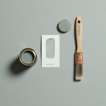 Paint can, brush, and paper on a gray background