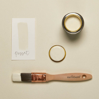 Paint can, brush, and color swatch on a beige background