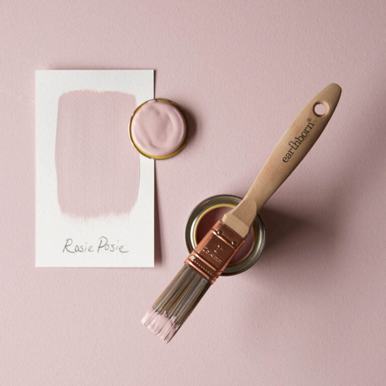 Paintbrush with 'earthborn' handle and container of pink paint on a pink background