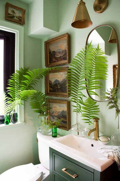 Bathroom with green walls, sink, mirror, and decorative elements.