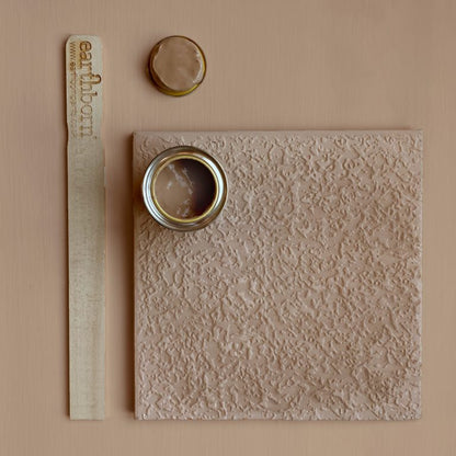 Textured wall panel with two small containers on a beige background