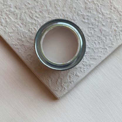Close-up of a can of paint on a textured surface