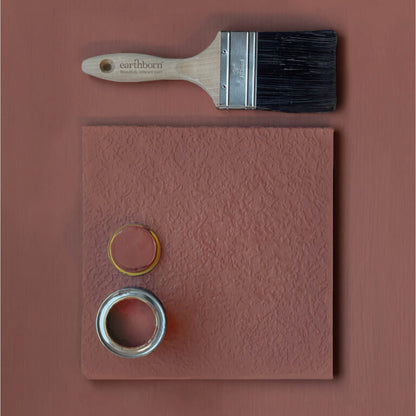 Paintbrush and paint samples on a pink background