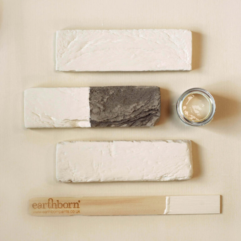 Set of natural skincare products including soap, cream, and wooden tool on a beige background with 'earlhamborn' branding.