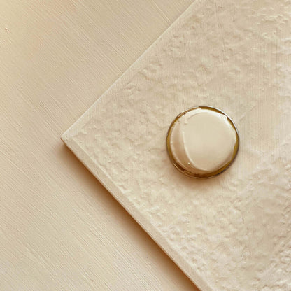 Gold ring on a textured beige surface