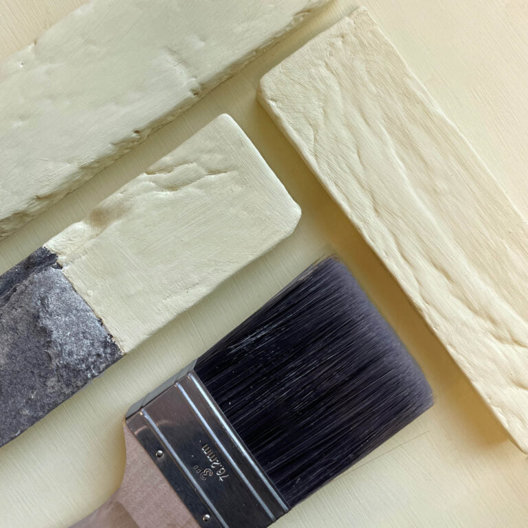 Paint brush with black bristles on a textured surface