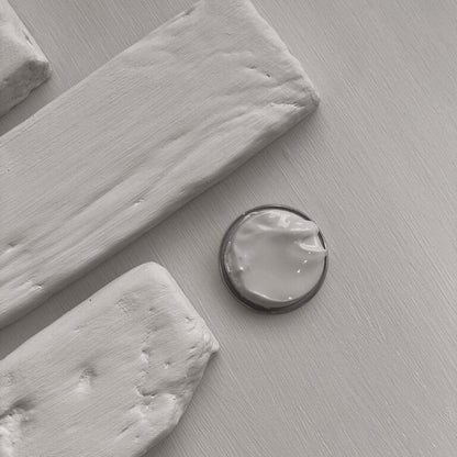 Close-up of a round metallic object on a textured gray surface with wooden elements.
