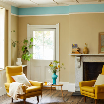 Living room with yellow armchairs, a fireplace, and decorative items.