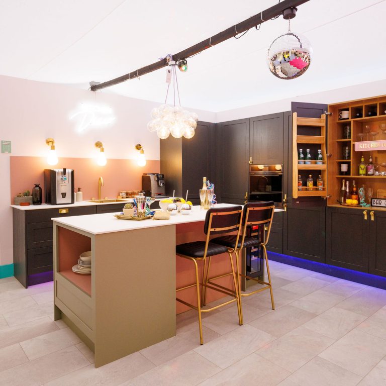Modern kitchen with island, bar stools, and open cabinets.