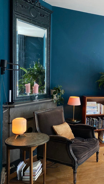Living room with dark blue walls, a gray armchair, and decorative items.