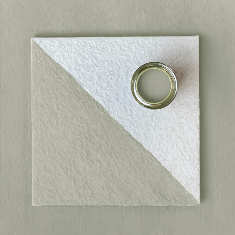 Square textured white tile with a circular cutout on a beige background