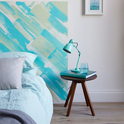 Room interior with a bed, lamp, and abstract wall art