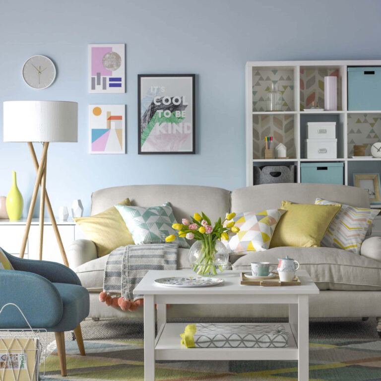 Modern living room with a beige sofa, blue armchair, and decorative elements.