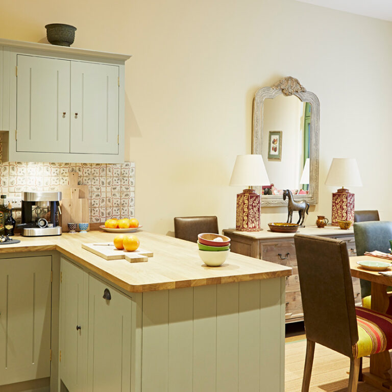 Kitchen with island and dining area, featuring a mirror on the wall.