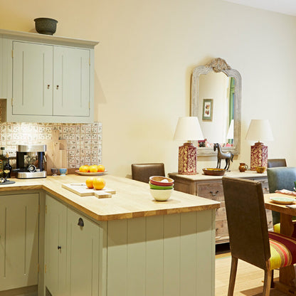Kitchen with island and dining area, featuring a mirror on the wall.