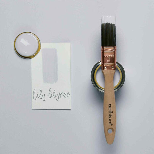 Paintbrush with wooden handle and metal bristles, surrounded by paint and a card on a gray background.