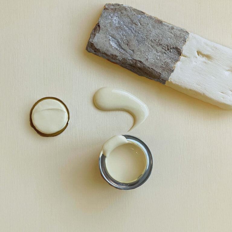 Wooden tool with white cream-like substance on a beige background