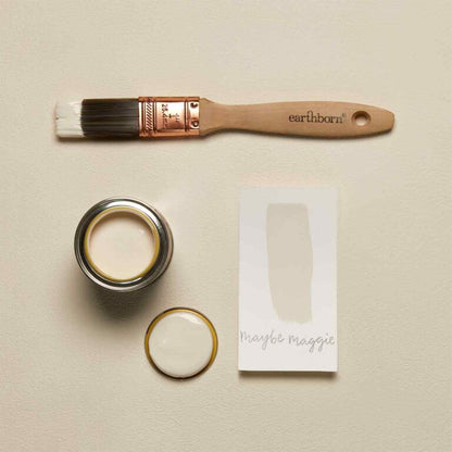 Earthborn paint brush, paint can, and packaging on a beige background