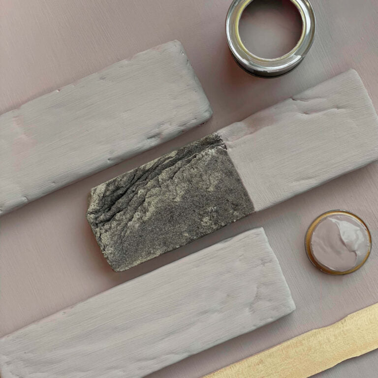 Various stones and a small container on a pink surface